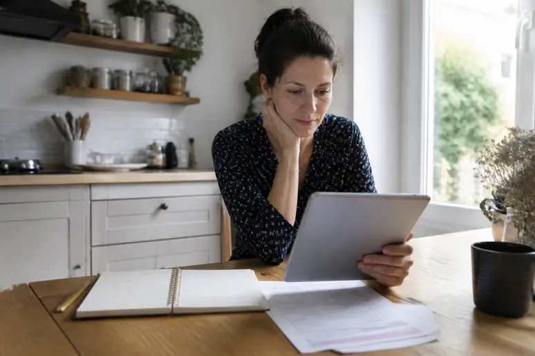 Femme française réalisant une simulation d'aides financières pour l'acquisition d'une pompe à chaleur chez elle.